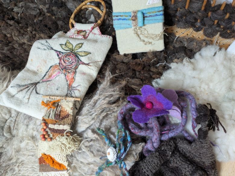 A picture of sheep fleece with a felt bag and wool
