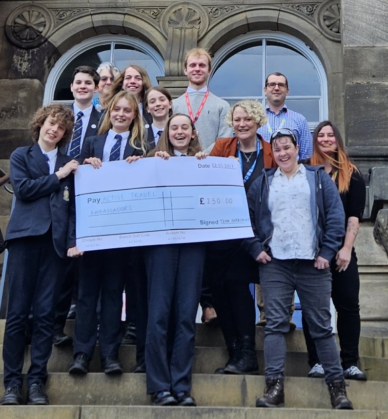 Student Active Travel Ambassador Team with oversizewd cheque for £200 on the steps of Leeds City Museum