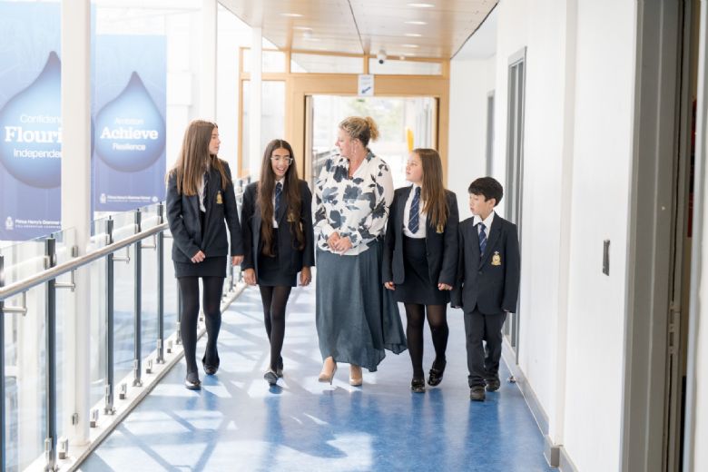  Sally Bishop talking to students walking along a corridor