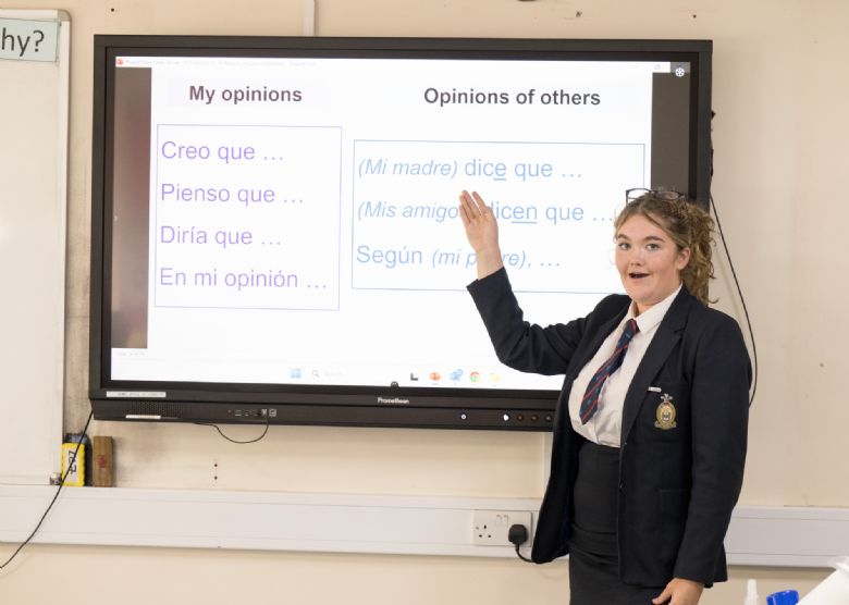teacher and student working in Spanish on a smartboard