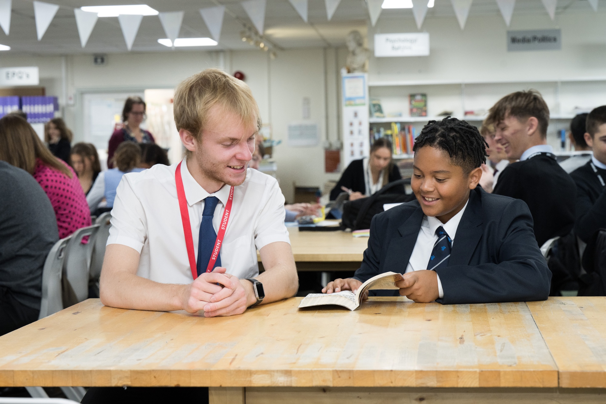 Sixth Former with younger student at reading club